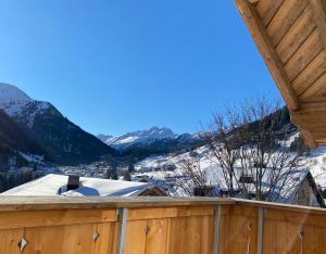 a view of a snowy mountain from a wooden fence at Chalet SILVER FOX - Luxus Chalets in Sankt Anton am Arlberg