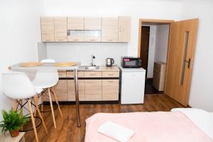 una pequeña cocina con fregadero y una mesa en una habitación en COSY STUDIO IN NOVE ZAMKY, en Nové Zámky