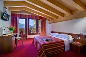 a bedroom with a bed and a large window at Hotel Sassella in Grosio