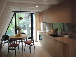 a kitchen with a table and chairs and a table and a counter at Domek Modern BRDA in Nysa