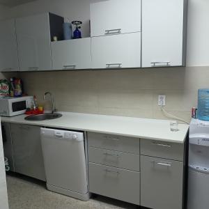 a kitchen with white cabinets and a sink and a microwave at Anika in Sutomore