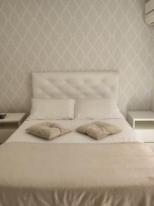 um quarto com uma cama branca e 2 almofadas em Amber 449 em Gramado