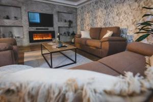 a living room with a couch and a fireplace at Museum Apartment in Subotica +31 photos
