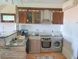 a kitchen with a sink and a washing machine at Studio Apartman Marti in Kostrena