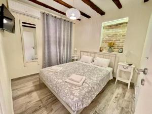a bedroom with a bed and a television in it at The well in Corfu
