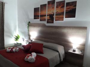 una camera da letto con un letto e due asciugamani di SHORT LETS Radici di Puglia a Fragagnano