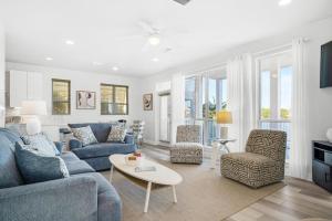 Una sala de estar con un sofá azul y sillas. en Destiny Beach Villas 17 Between the Waters, en Destin