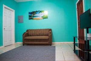 a living room with a couch and a blue wall at Bliss on the Bay family in West End
