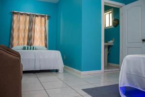 a room with two beds and a blue wall at Bliss on the Bay family in West End