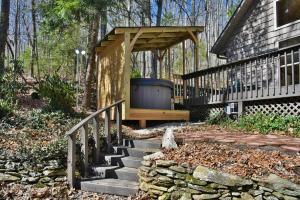 アッシュビルにあるThe Camby Cabin just 12 miles to downtown Ashevilleの木製のパーゴラ付きのポーチ、家の隣の階段