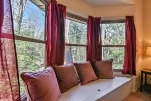 a couch sitting in front of a window with red curtains at The Camby Cabin just 12 miles to downtown Asheville in Asheville