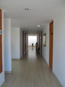 an empty hallway with white walls and wood floors at Hotel Kariary in Puerto Boyacá