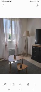 ein Wohnzimmer mit einem Tisch und einem Fenster in der Unterkunft Gite du golf bis in Gonneville-sur-Mer