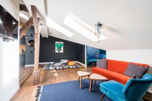 een woonkamer met een oranje bank en blauwe stoelen bij Wegierska Luxury Loft WAWELOFTS in Krakau