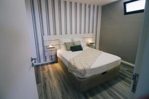 una camera da letto con un letto con lenzuola e cuscini bianchi di Casa do Brasileiro ad Arco da Calheta