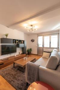 a living room with a couch and a flat screen tv at Luminoso apartamento en Cuatro Caminos in A Coruña