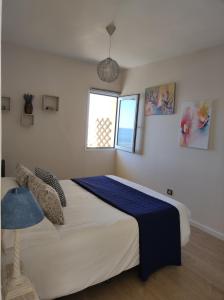Un dormitorio con una cama con una manta azul. en Vista San Juan en San Juan de la Rambla
