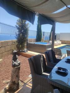 a patio with a table and chairs and a pool at LUXURY VILLA Atlantico Views in Candelaria