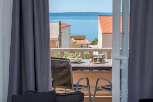 balkon z 2 krzesłami i widokiem na wodę w obiekcie Apartment Sole Mio -Sea view w Makarskiej