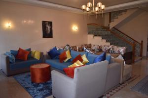 ein Wohnzimmer mit einem blauen Sofa und bunten Kissen in der Unterkunft Villa Marrakech in Marrakesch