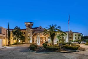 Un gran edificio con una palmera delante. en Best Western Gateway Grand, en Gainesville
