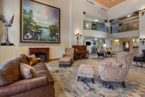 a living room with a couch and chairs and a piano at Best Western Gateway Grand in Gainesville