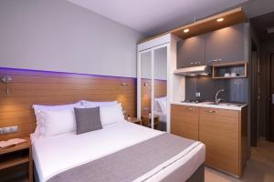 a bedroom with a bed and a sink in it at SKS Luxury Suites & Rooms in Paralia Katerinis