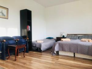 a room with two beds and a chair at Apartament Teatralny in Gdańsk