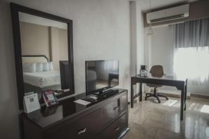 een hotelkamer met een televisie en een bureau bij Best Western Plus Tuxtepec in San Juan Bautista Tuxtepec