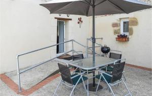 einen Tisch und Stühle mit Sonnenschirm auf einer Terrasse in der Unterkunft Gorgeous Home In Le Busseau With Wifi in Le Busseau