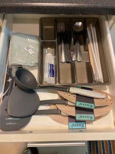 a drawer with knives and utensils in it at M Kasetsart in Ban Yang