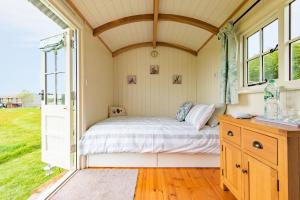 a bed in a small room with a window at Mist Sheperd's Hut by Bloom Stays in Egerton
