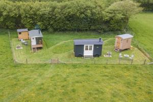 a group of tiny houses in a field at Mist Sheperd's Hut by Bloom Stays in Egerton