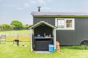 a green shed with a table and a table at Mist Sheperd's Hut by Bloom Stays in Egerton