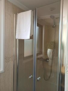 a shower with a glass door with a white towel at A casiña de Estela in Caldas de Reis +28 photos