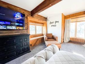 a living room with a couch and a flat screen tv at Private Mountain Cabin! King Bed 8 Acres Game Rm in Eastonville