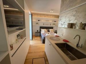 uma cozinha com um lavatório e uma cama num quarto em Palazzo Metropolis em Bari
