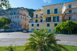 a group of buildings with a palm tree in the foreground at Palazzo Della Monica in Vietri sul Mare