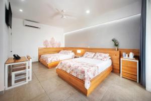 a bedroom with two beds and a television in it at Naboo Resort & Dive Center - Adults Only in West Bay +89 photos