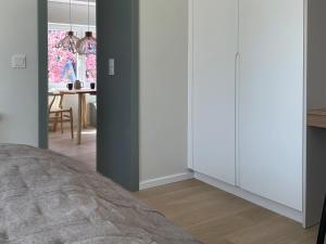 a bedroom with white cabinets and a dining room at Ferienwohnung Henny in Wyk auf Föhr