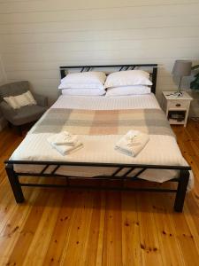 - un lit avec 2 serviettes dans une chambre dans l'établissement DELIGHTFUL AND CHARMING ROSE COTTAGE, à Kilmore