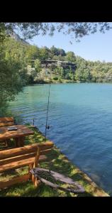 a lake with a wooden bench and a fishing pole at Villa on the lake near Mostar in Jablanica +17 photos