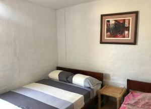 1 dormitorio con 2 camas y una foto en la pared en Casa Máncora Guesthouse, en Máncora