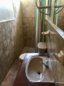 La salle de bains est pourvue d'un lavabo et de toilettes. dans l'établissement Casa Máncora Guesthouse, à Máncora