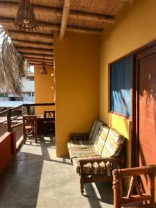 - une terrasse couverte avec un canapé sur le côté du bâtiment dans l'établissement Casa Máncora Guesthouse, à Máncora