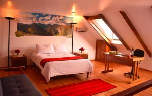 1 dormitorio con cama, escritorio y ventana en Los Aticos B&B with Coworking, en Cusco