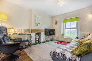uma sala de estar com um sofá e uma televisão em Hillside Cottage em Bath