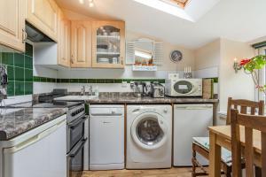a kitchen with a washing machine and a washer and dryer at Hillside Cottage in Bath +17 photos