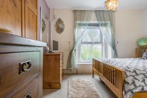 1 dormitorio con cama y ventana en Hillside Cottage, en Bath