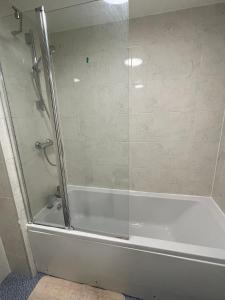 La salle de bains est pourvue d'une douche avec une porte en verre. dans l'établissement Newbuild - 3 bedrooms, 2 baths,5 mins from airport, à Édimbourg